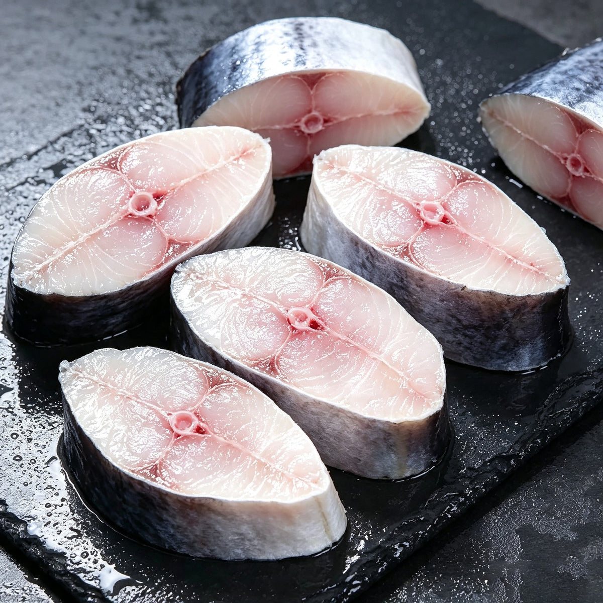Thick Spanish mackerel steaks on a slate board